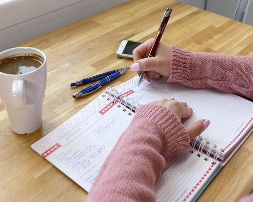 Person organizing their morning tasks at a table