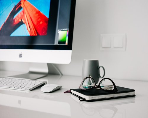 Glass of water near a laptop on a home office desk